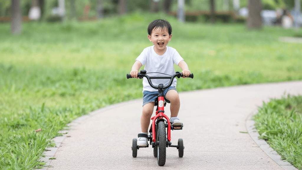 bici bambino 3 anni su percorso nel parco con rotelle laterali