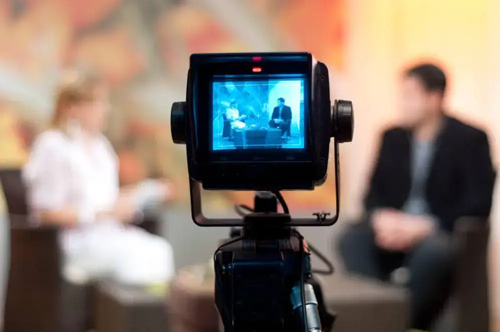 Interview recording setup in a studio with two people speaking.