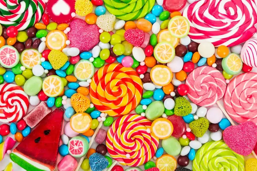 Bright assortment of candies, lollipops, and gummies in vibrant colors and shapes.