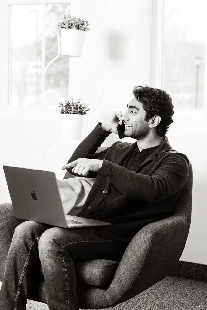 man sitting on a chair talking on the phone