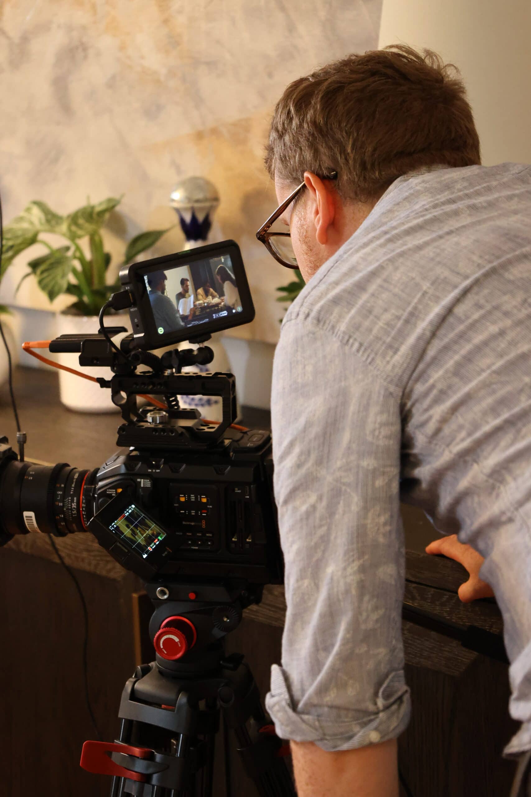 Filmmaker recording a video for performance marketing campaign with professional camera.