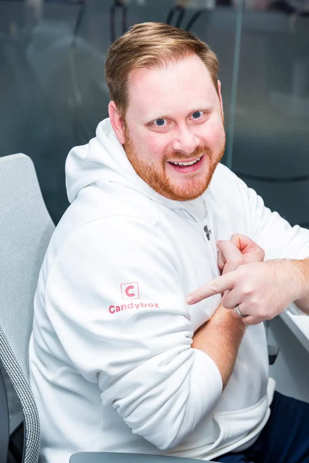 Smiling man in white hoodie promoting career opportunities at Candybox.
