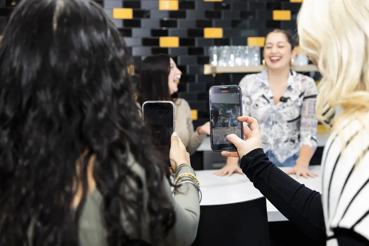 Women capturing photos at a service event, showcasing community engagement and social interaction.