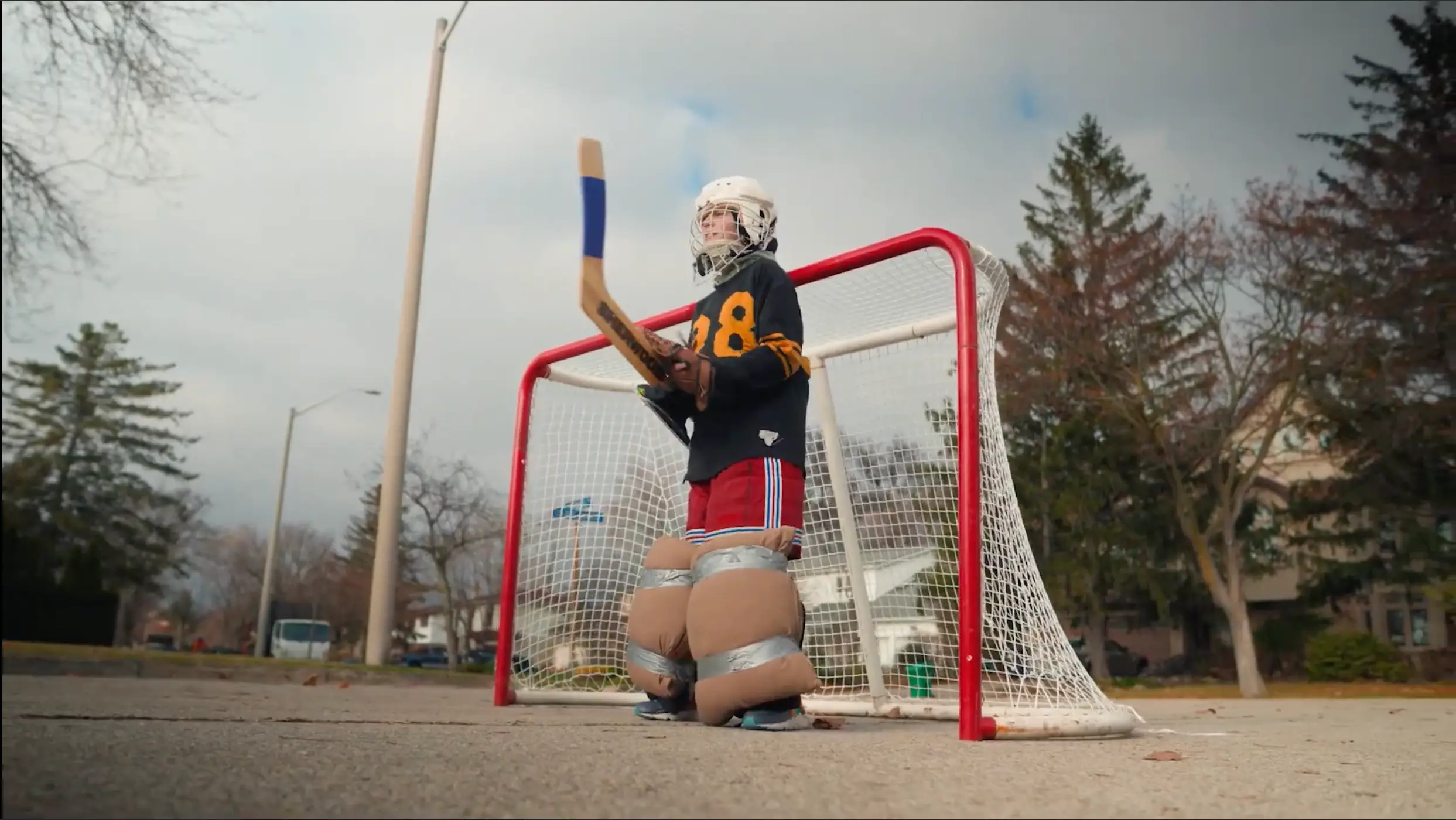 Hockey goalie in full gear standing in front of the net during practice.
