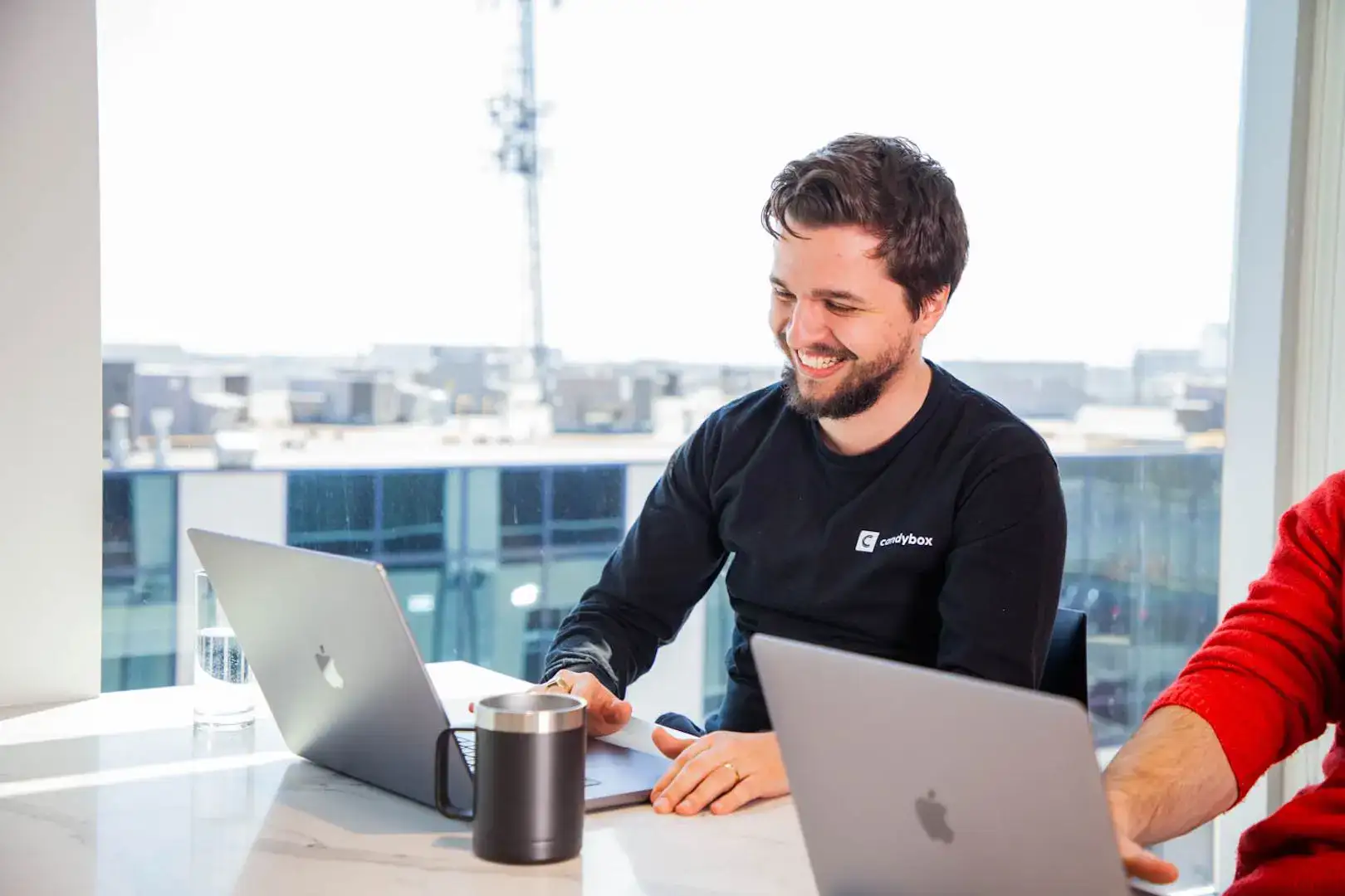 Business professional smiling during a measurement and reporting team meeting.