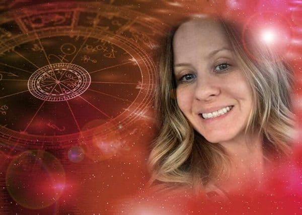 Cartomante Linda con carte e simboli zodiacali.