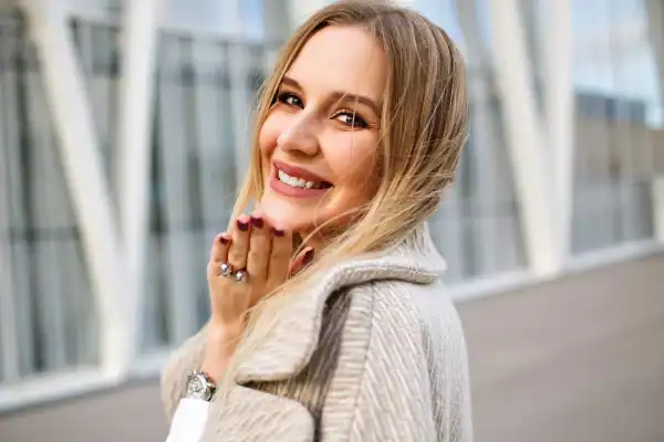 Sorriso radioso di una donna felice all'aperto.