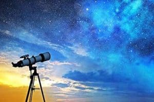Telescopio puntato verso il cielo stellato, simbolo di ricerca tra scienza e astrologia.