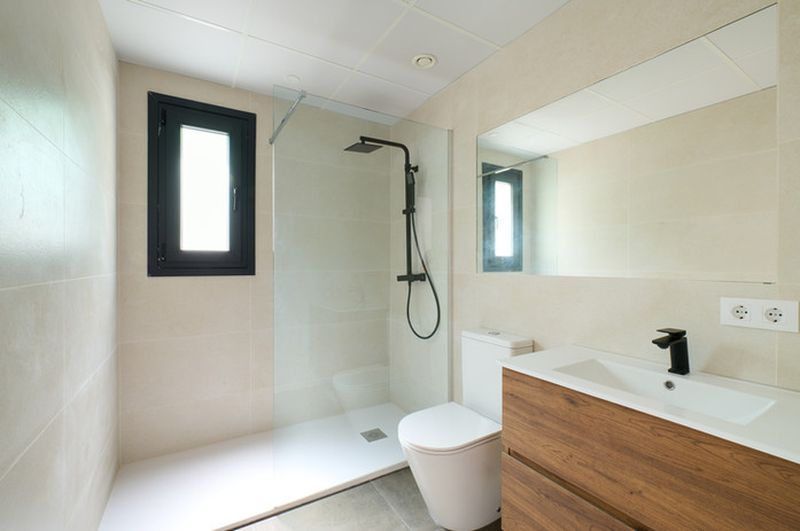 Cuarto de baño moderno con ducha y ventana.