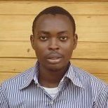Professional man with a blue striped shirt standing in front of a wooden background.