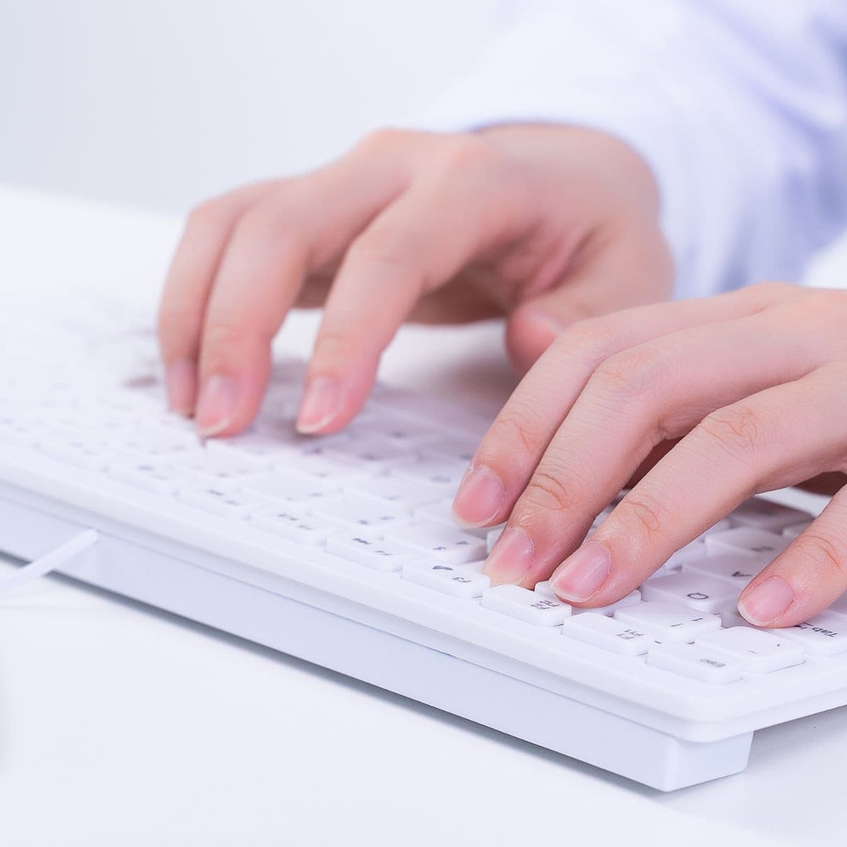 Hands typing on a computer