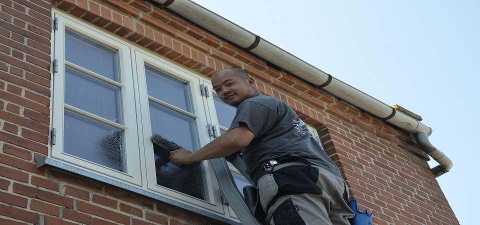 Vinduespudser i Hillerød ses her arbejde med vinduespolering hos en kunde