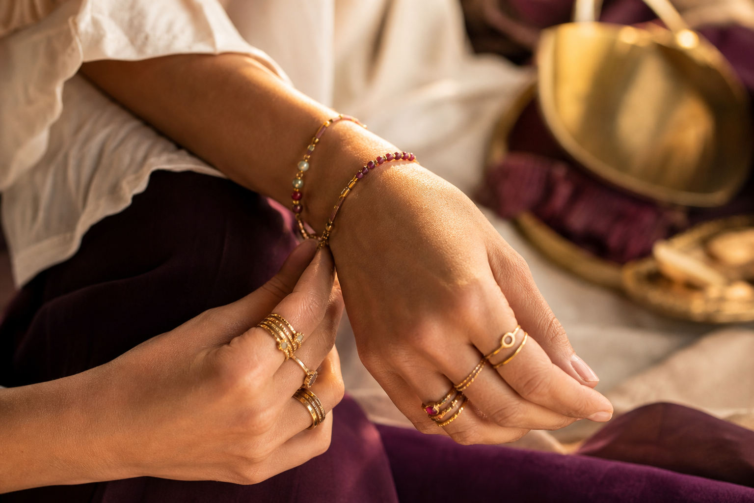 Mains aux bagues fines dorées empilées, bracelets superposés