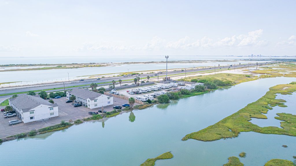 Portland, TX RV Park Aerial view of Portland RV Park in Portland, Texas near coastal water, parking lots, wetlands, and Corpus Christi Boardwalk.