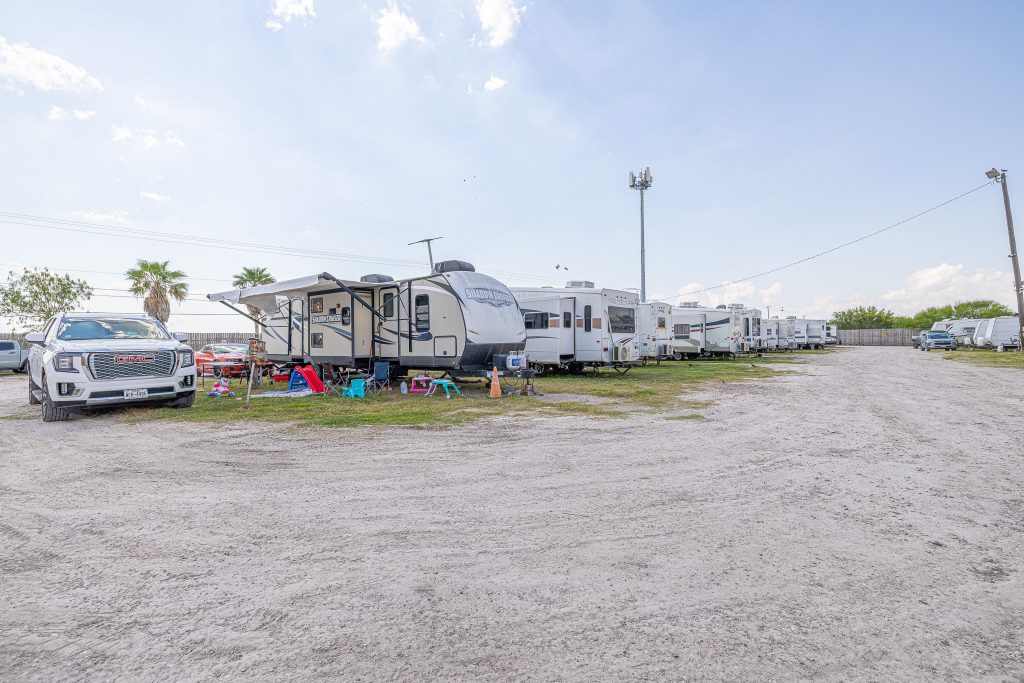 Portland, TX RV Park RVs and trailers at Portland RV Park in Portland, Texas, with a white truck, palm trees, and outdoor chairs on gravel lot.
