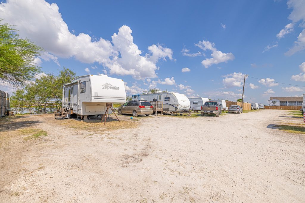 Portland, TX RV Park Portland RV Park in Portland Texas with RVs and cars on gravel lot, blue sky, scattered clouds, trees and open space.