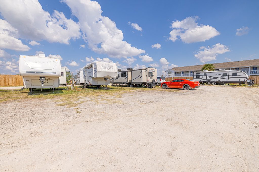 Portland, TX RV Park Portland RV Park in Portland, Texas featuring gravel lot, white RVs, red car, apartment building, and blue sky with clouds.