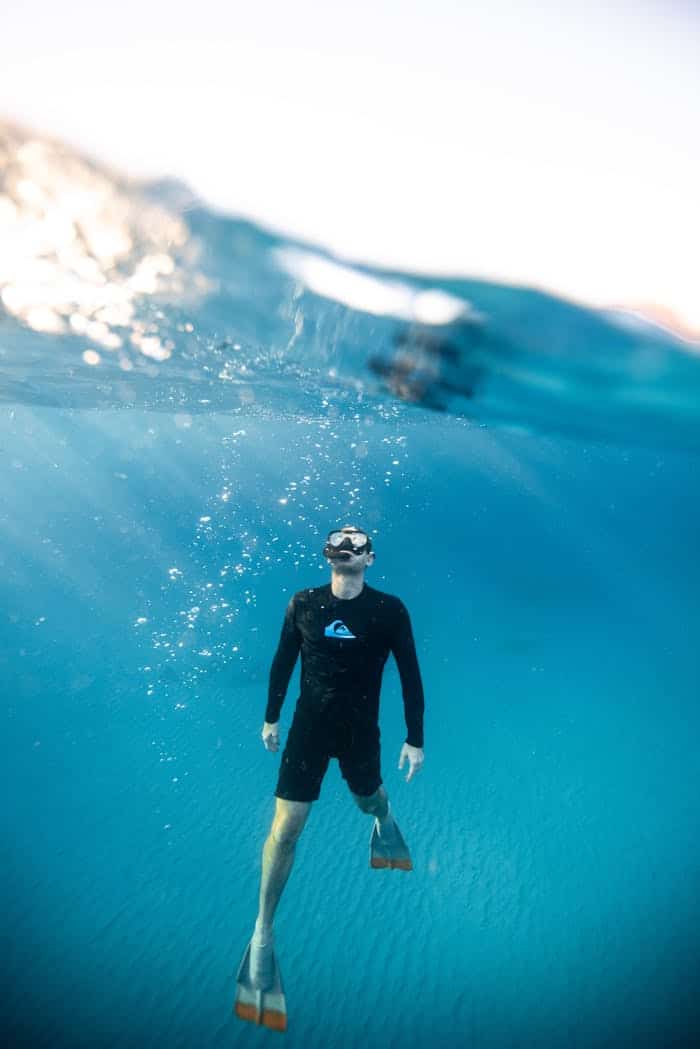 embark Man snorkeling in vibrant Hawaiian waters, showcasing underwater exploration and aquatic adventure.