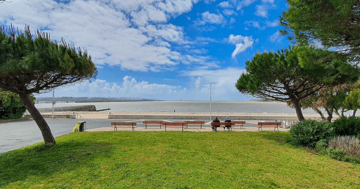 Menschen auf Bank vor dem Meer in La Rochelle