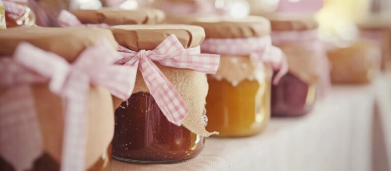 Tarros de mermelada con lazos rosados en mesa