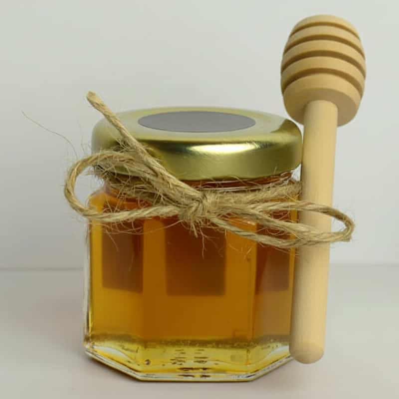 Tarro de miel con cuchara de madera