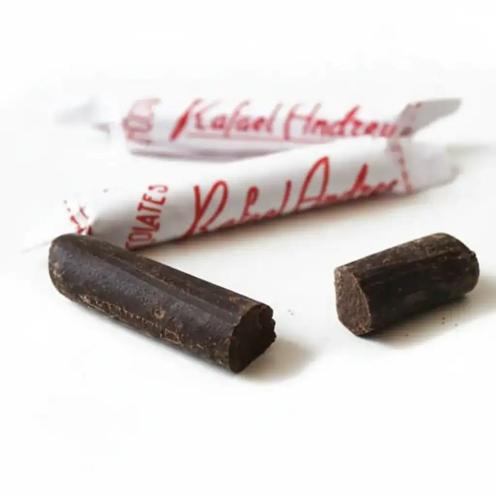 Dos tabletas de chocolate negro frente a un envoltorio.