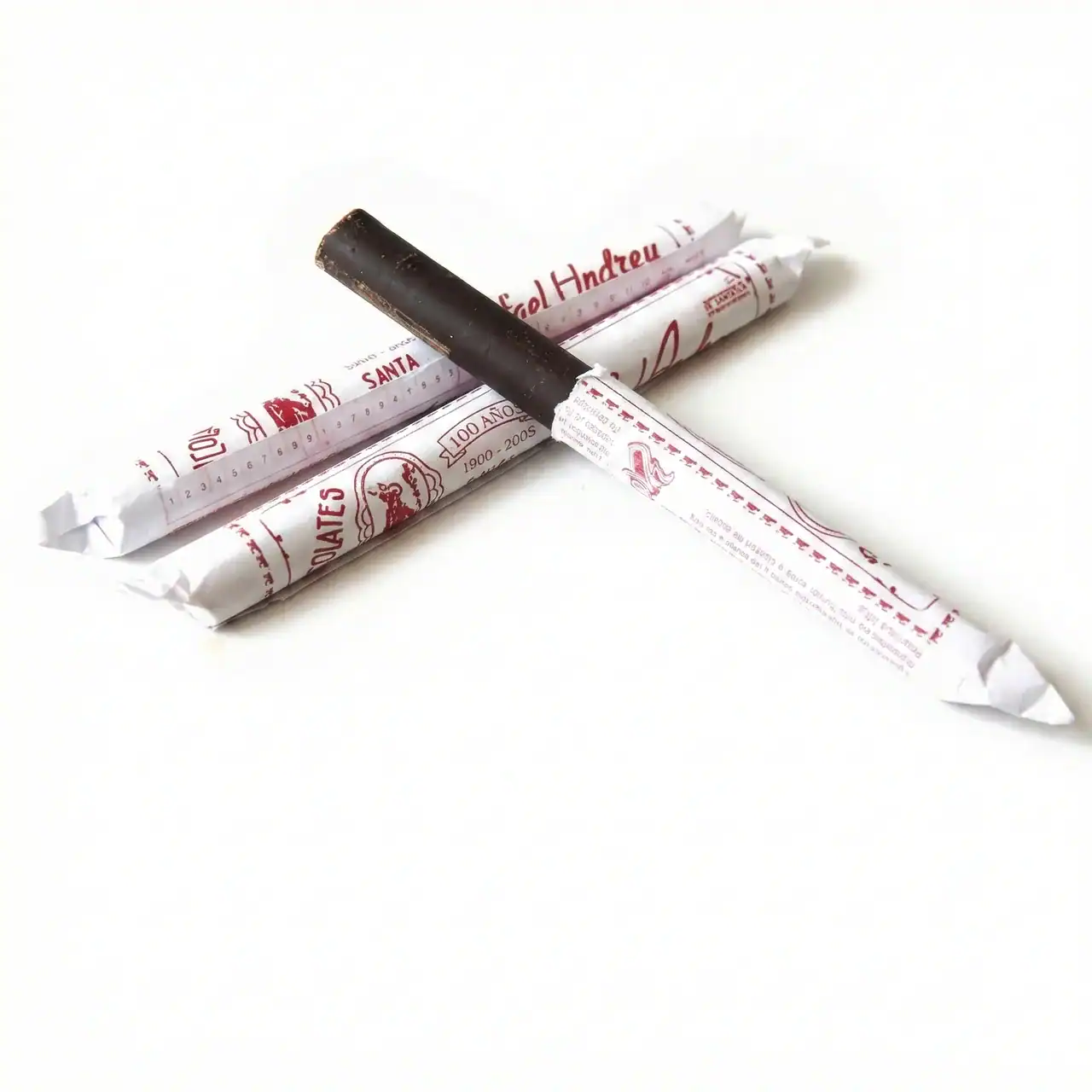 Cuatro chupetes de regaliz en sus envoltorios.