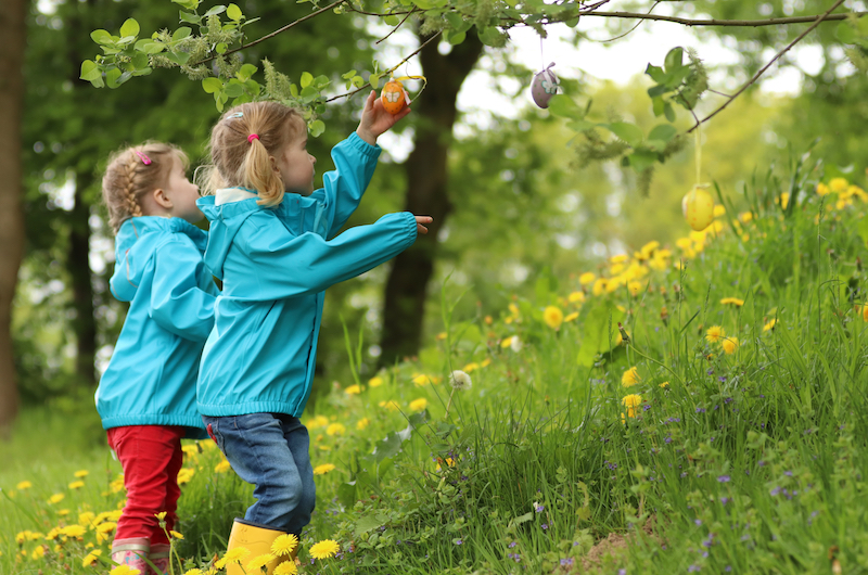 Zwei Mädchen spielen an einem Baum
