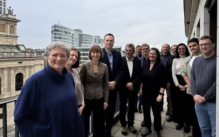 1. Gruppe von Menschen auf Dachterrasse mit Blick auf Berliner Stadtbild, Business Kleidung.