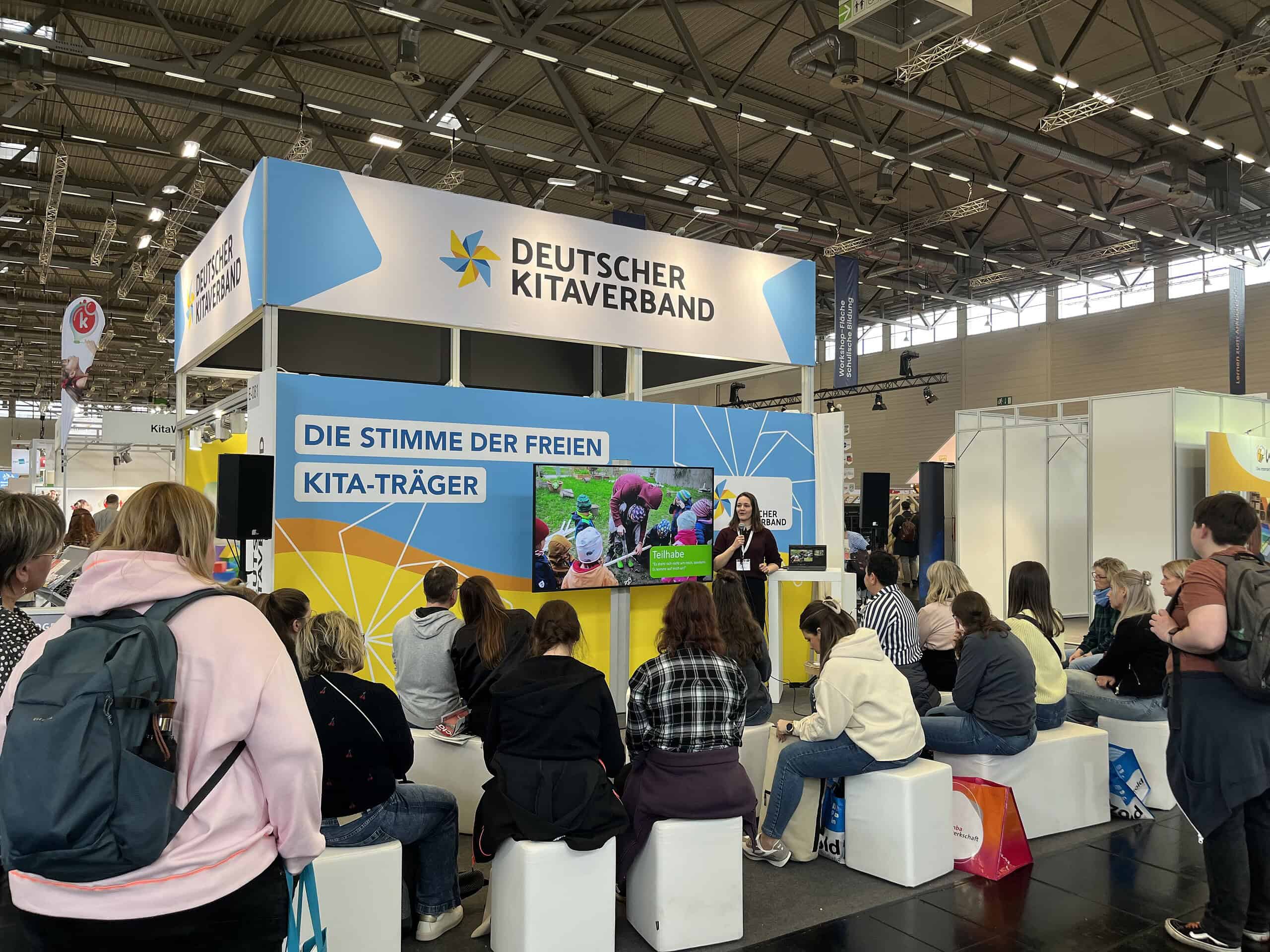 Deutscher Kitaverband Stand auf der Didacta 2026 mit Publikum und Präsentation.