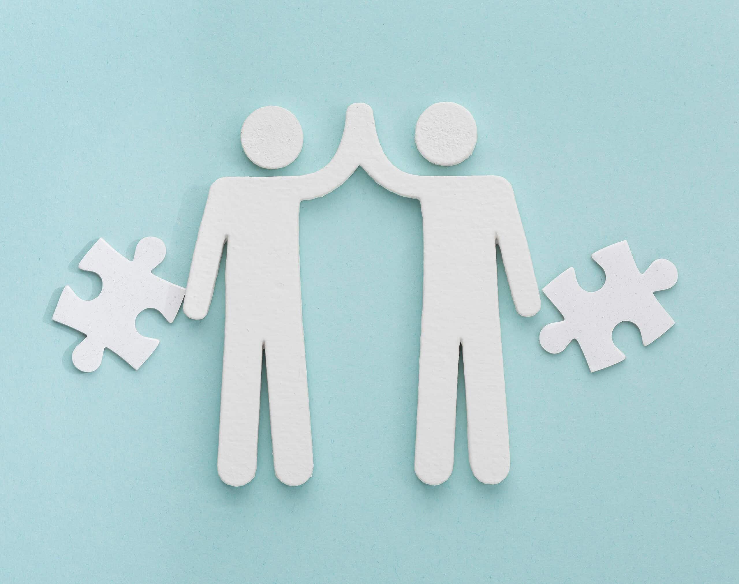 Zwei Figuren mit Puzzlestücken, symbolisieren Zusammenarbeit im Bereich frühkindliche Bildung.