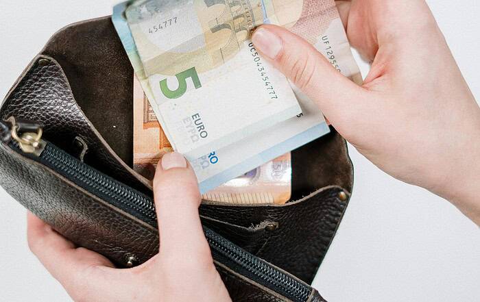 Geldbörse mit Euro-Banknoten, die aus einer Tasche gezogen werden.