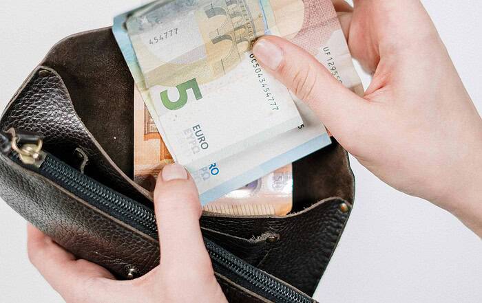 Geldbörse mit Euro-Banknoten, die aus einer Tasche gezogen werden.