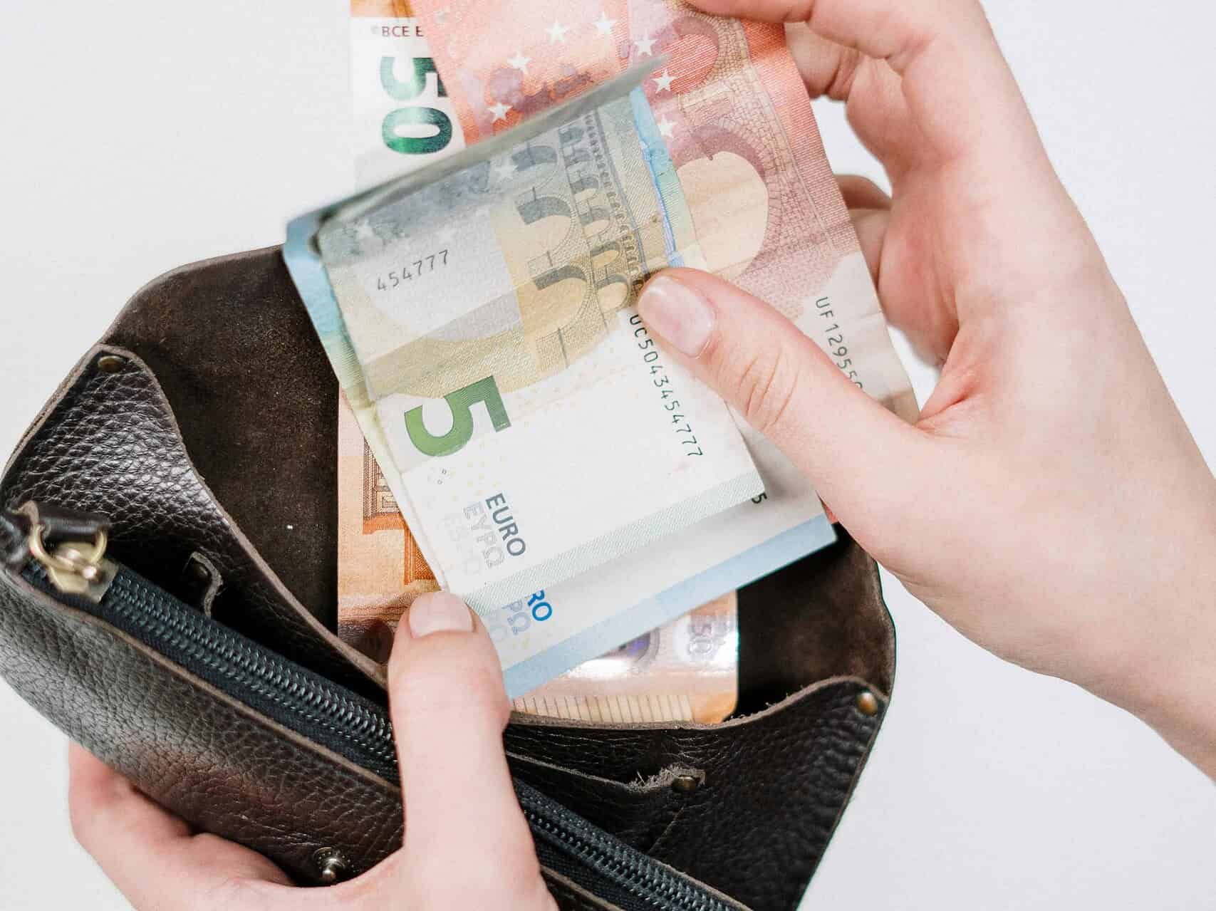 Geldbörse mit Euro-Banknoten, die aus einer Tasche gezogen werden.