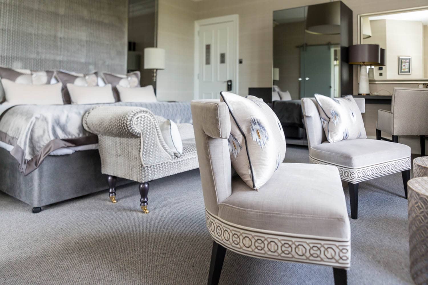 Elegant hotel room with a large bed and stylish seating area in Moray, Scotland.