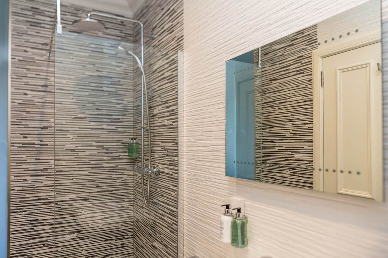 Modern bathroom shower with striped tile walls at The Dowans Hotel Speyside Moray.