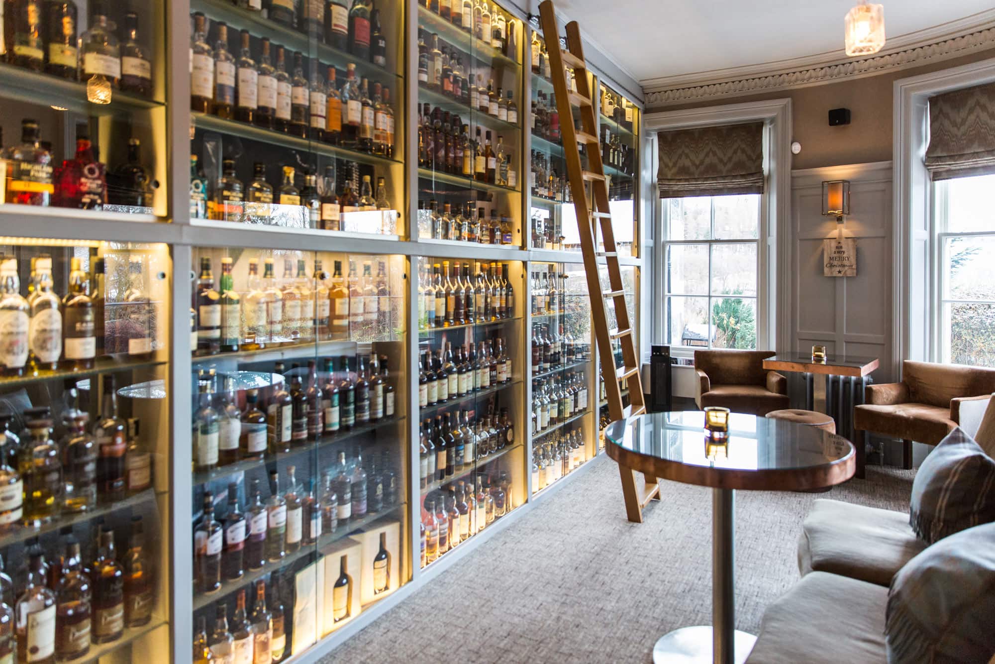 Interior view of The Still Whisky Bar at Dowans Hotel in Moray, showcasing a wide selection of spiri.