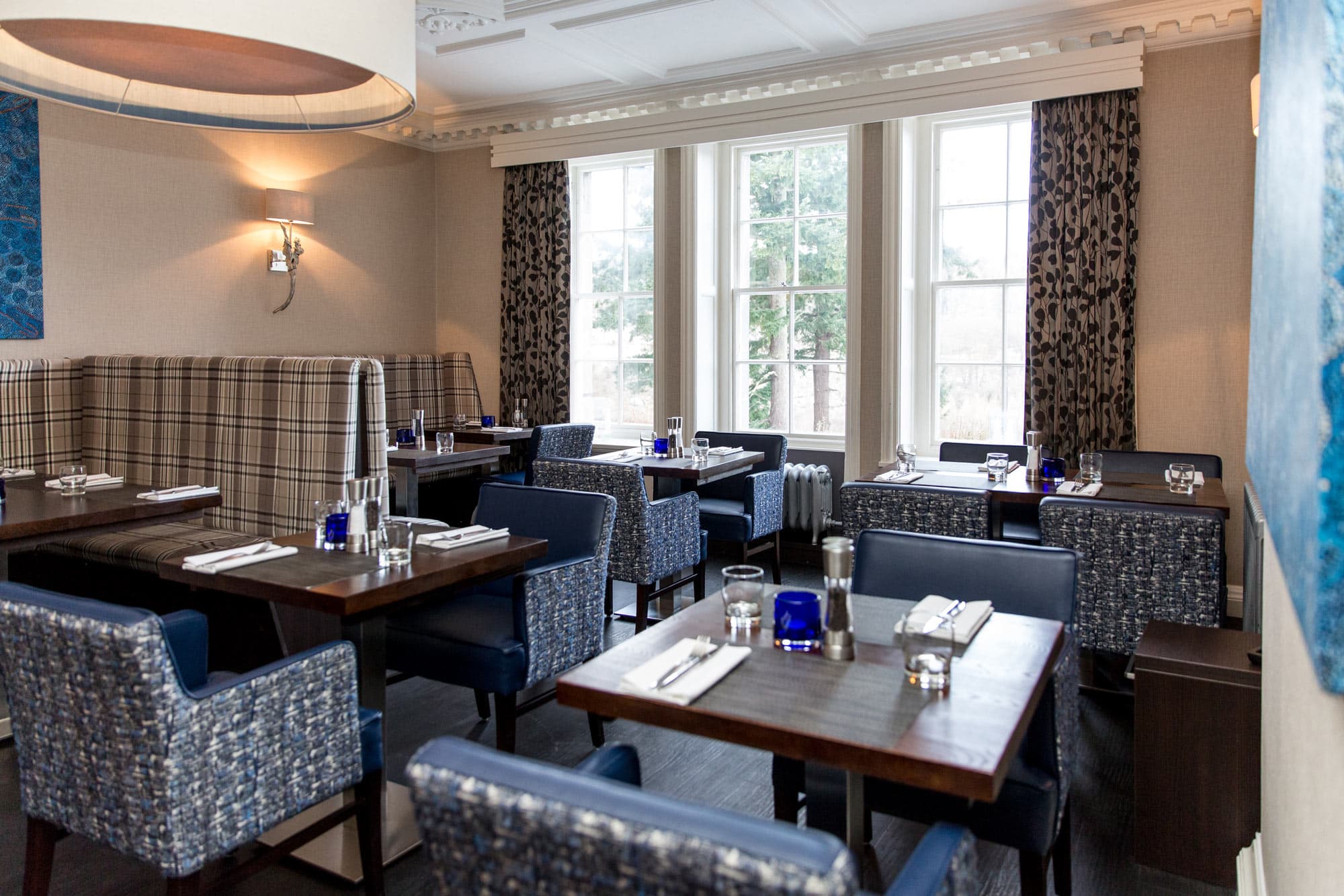 Elegant dining room at The Dowans Hotel Speyside Moray with large windows and stylish decor.