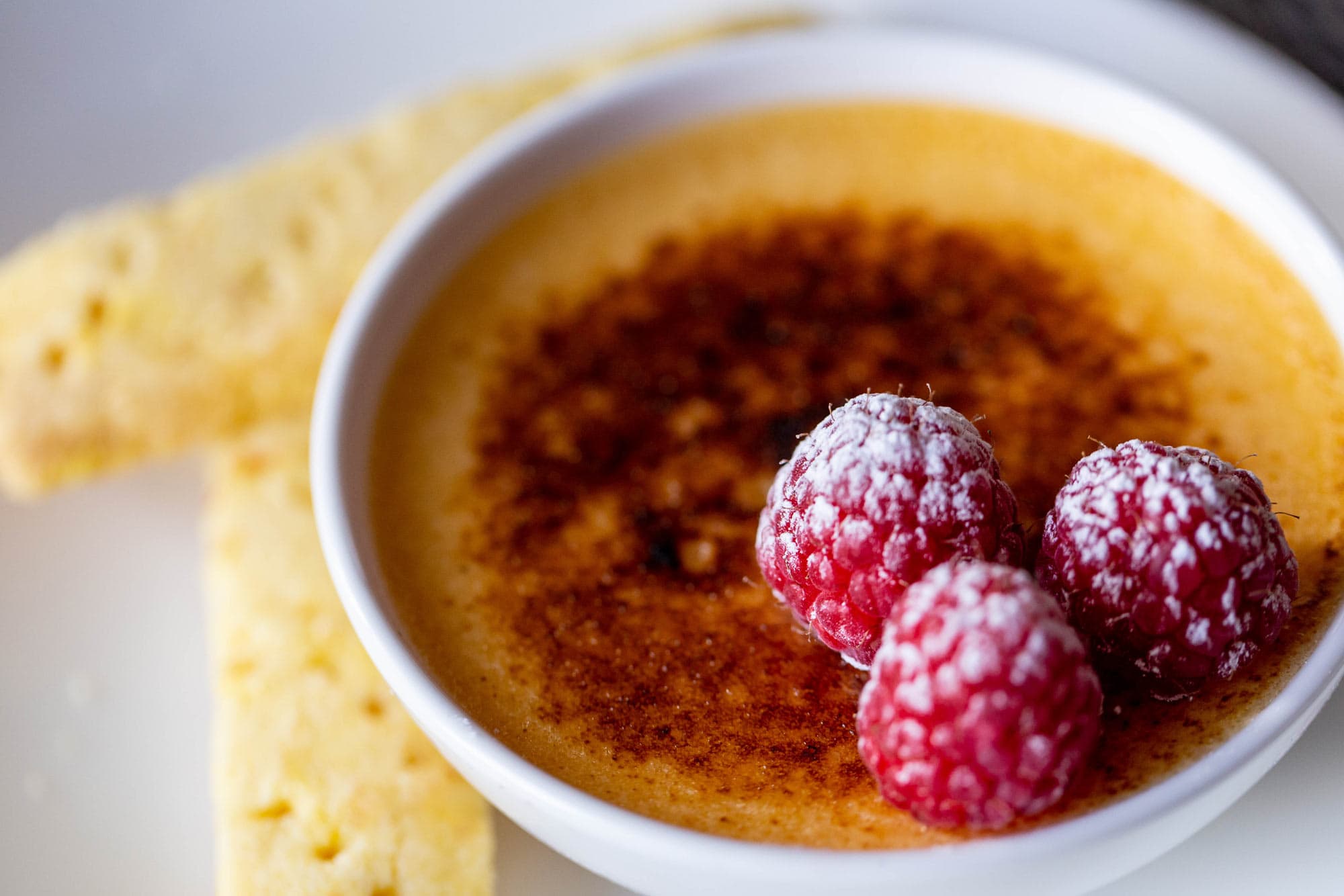 Delicious crème brûlée topped with fresh raspberries and caramelized sugar, served at The Dowans Hot.