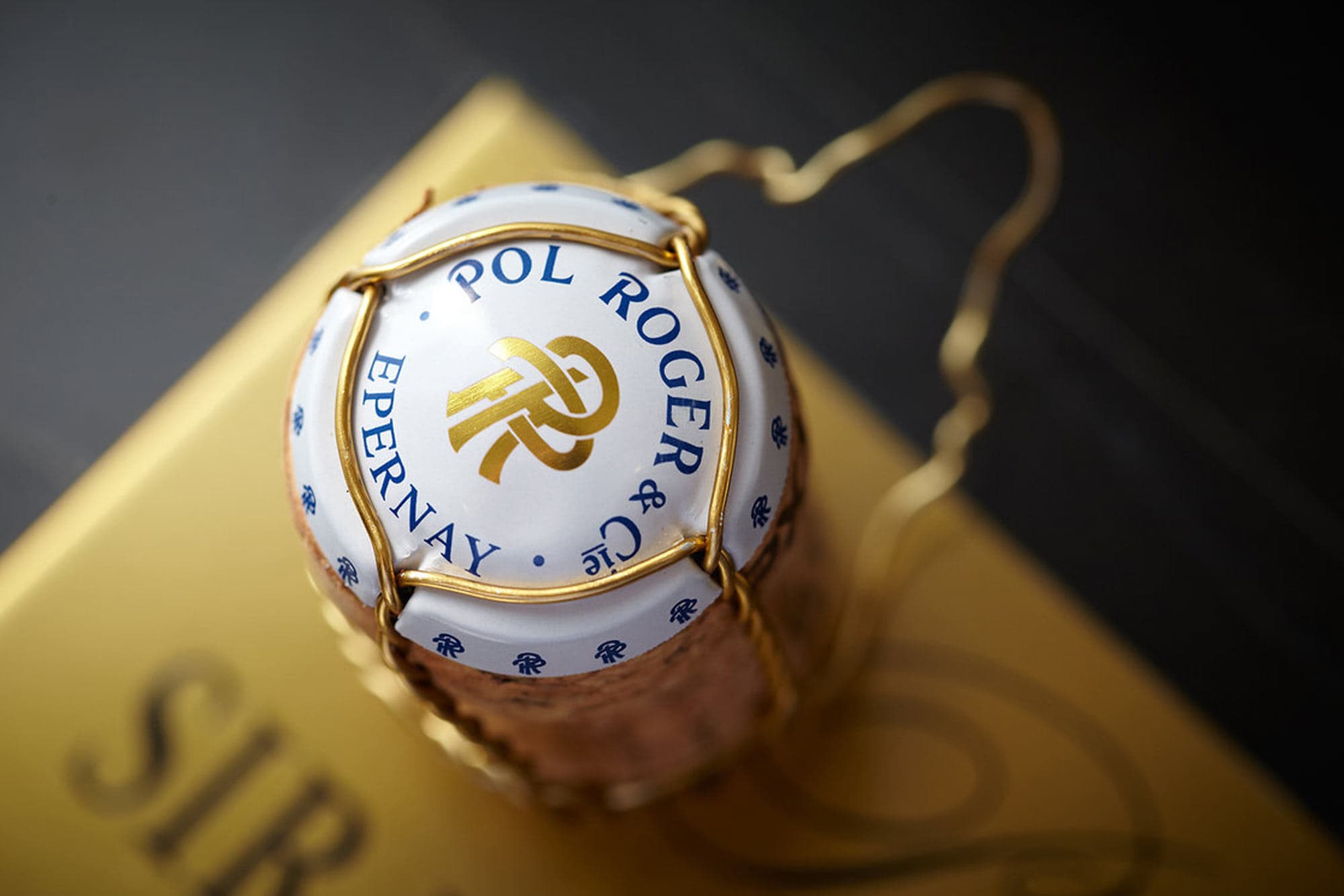 Pol Roger champagne bottle with gold foil and label detail.