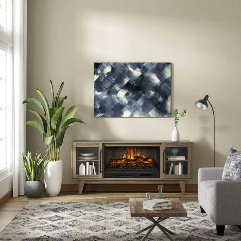Modern living room with electric fireplace, abstract wall art, patterned rug, and potted plants