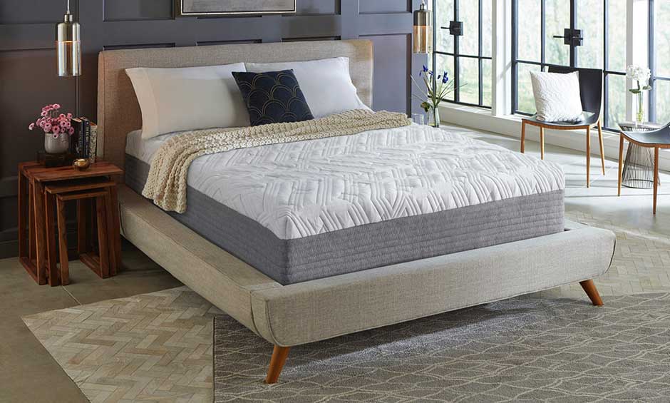 Modern bedroom with gray and white mattress, beige bed frame, and large windows