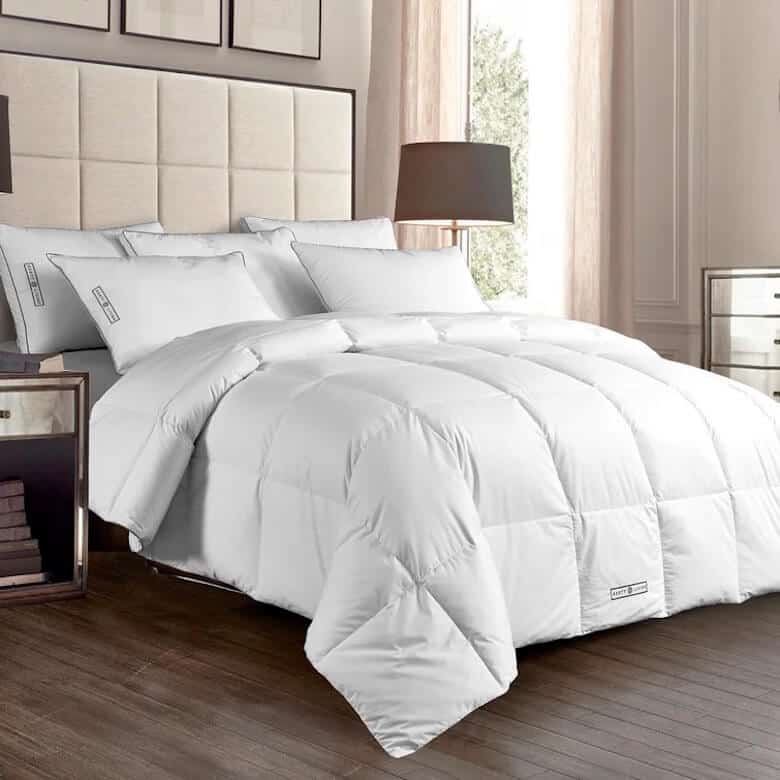 Bed with a white comforter, pillows, and bedside lamps