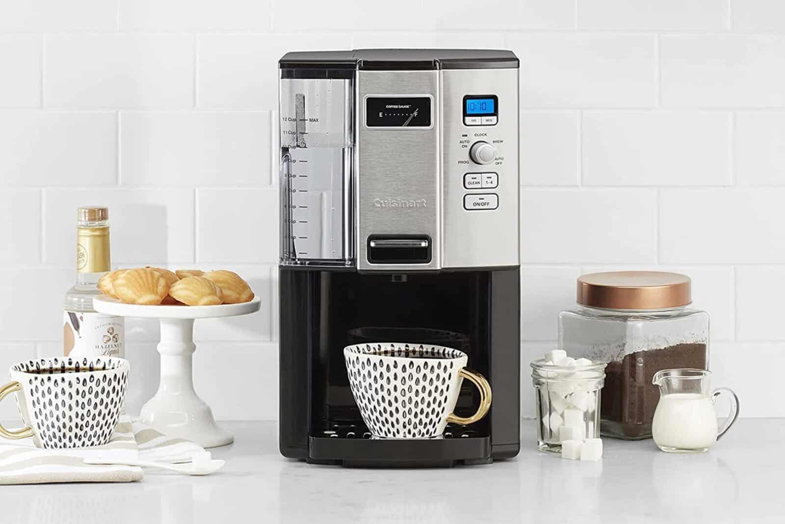 Cuisinart coffee maker with mug, sugar, milk, cookies, and coffee jar on counter