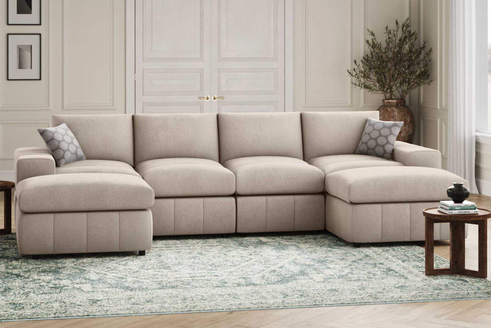 Light beige sectional sofa with decorative pillows, coffee table, and a potted plant in a living room