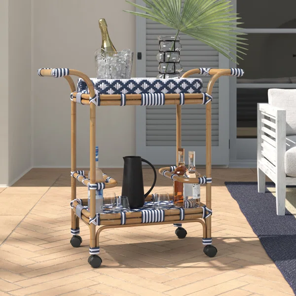 Wicker bar cart with drinks and palm leaf centerpiece