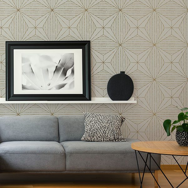 Gray geometric wallpaper with black-and-white art above a gray couch and wooden coffee table