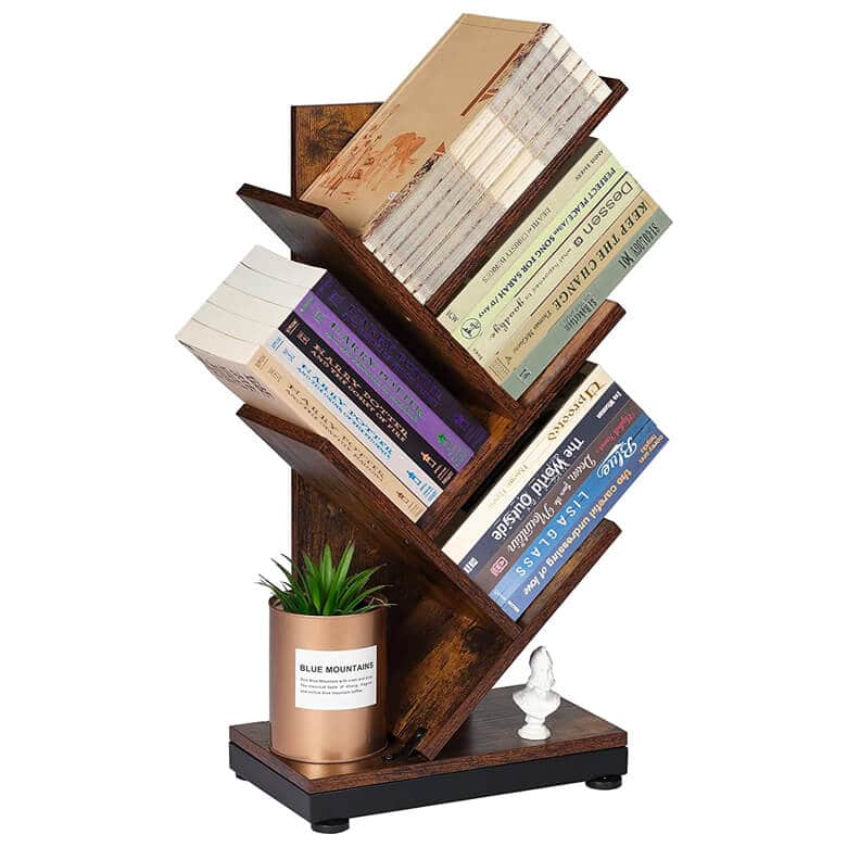 Wooden tree-shaped bookshelf holding various books, a small potted plant, and a decorative bust