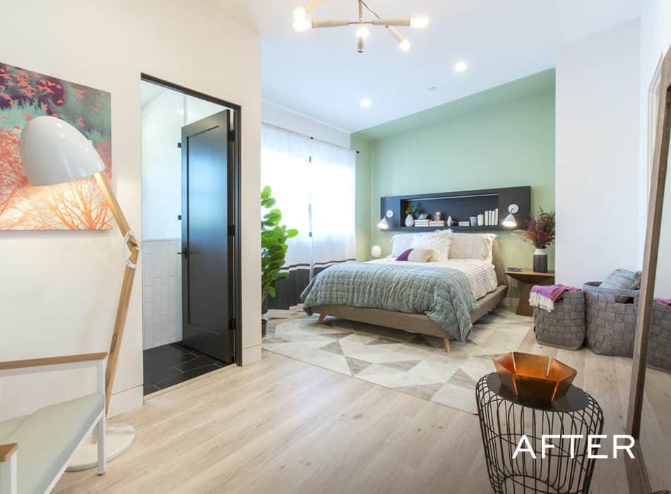 Modern bedroom with green accent wall, cozy bed, and light wood floors
