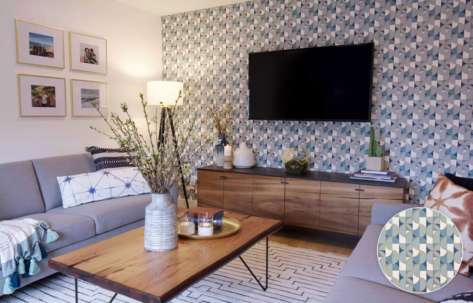 Living room with patterned wall, wood console, and grey sofas